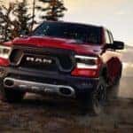 Red Ram 1500 on dusty road coming toward camera