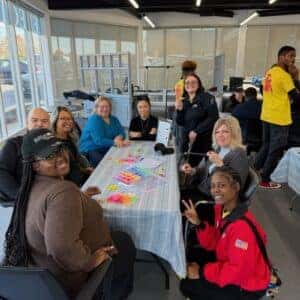 team members and a americorps member making bracelets