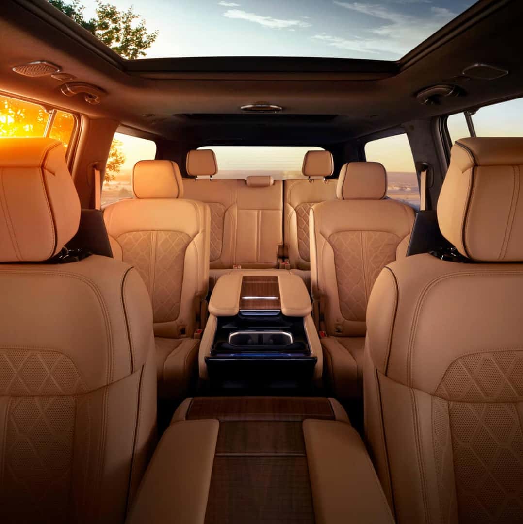Full interior look back view of a Jeep Grand Wagoneer three-row cabin in Tupelo leather at sunset.