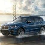 BMW X3 Driving Over a Bridge on Wet Road
