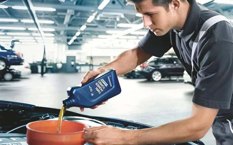 BMW Mechanic Pouring Oil Into Filter