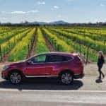 Exterior side view of the 2021 Honda CR-V Hybrid with woman approaching from right side. Farmland in background