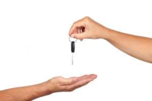 Two human hands, one returns a set of keys to the outreached palm of another