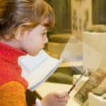 Boy and little girl at excursion in historical museum near exhib
