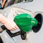 Person filling gas tank of car