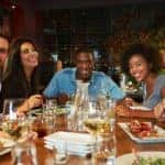 Half circle of friends smiling during dinner