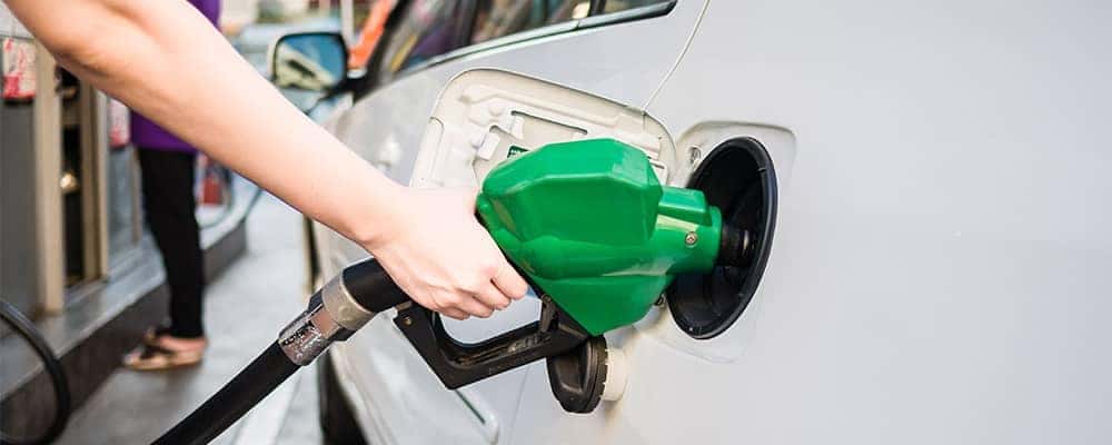 Person filling gas tank of car