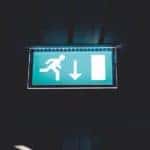 Exit sign with arrow pointed down and person running