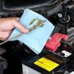 Oil mechanic checking oil on blue cloth