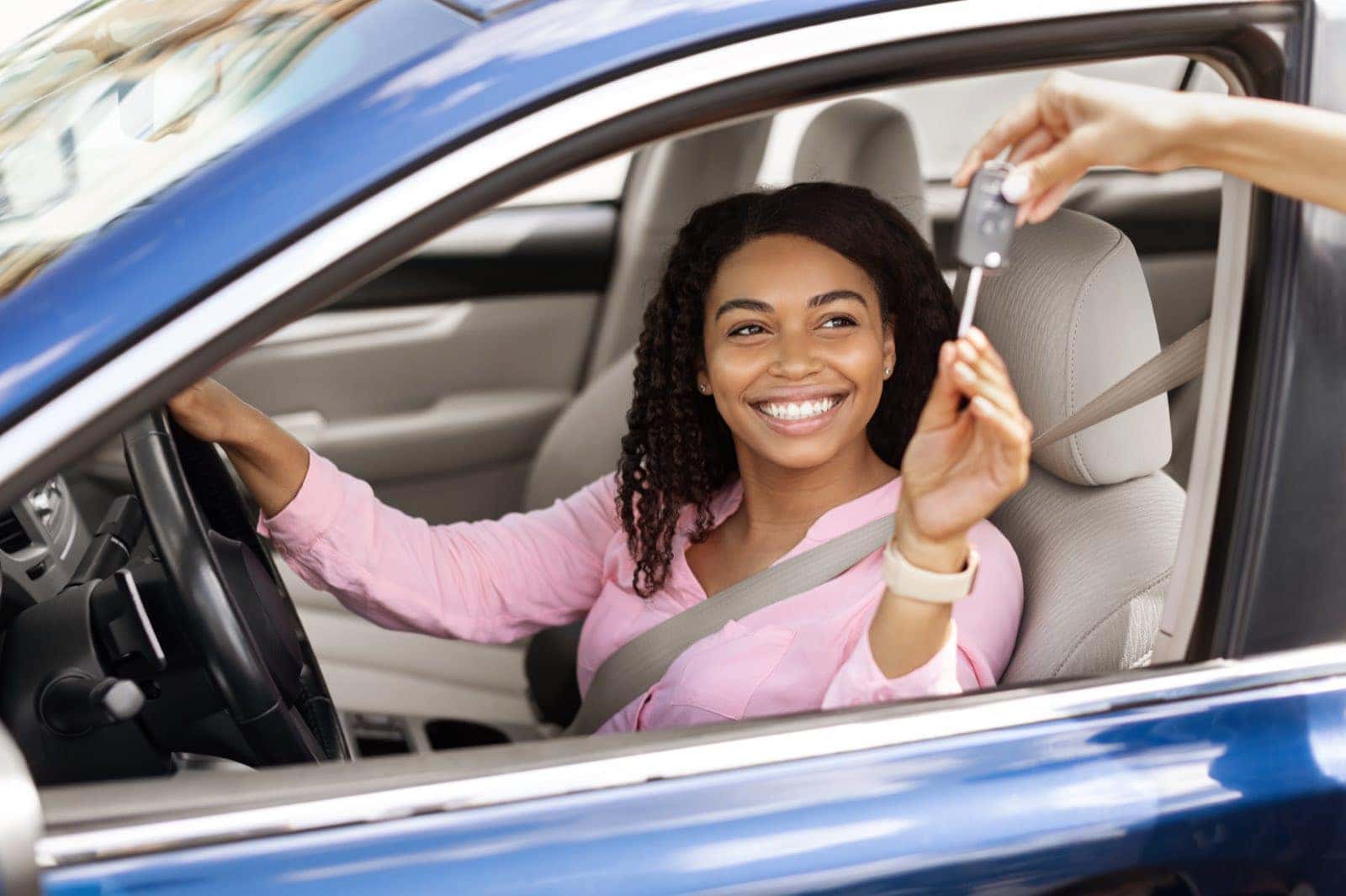 Driver sitting in a new car holding the keys