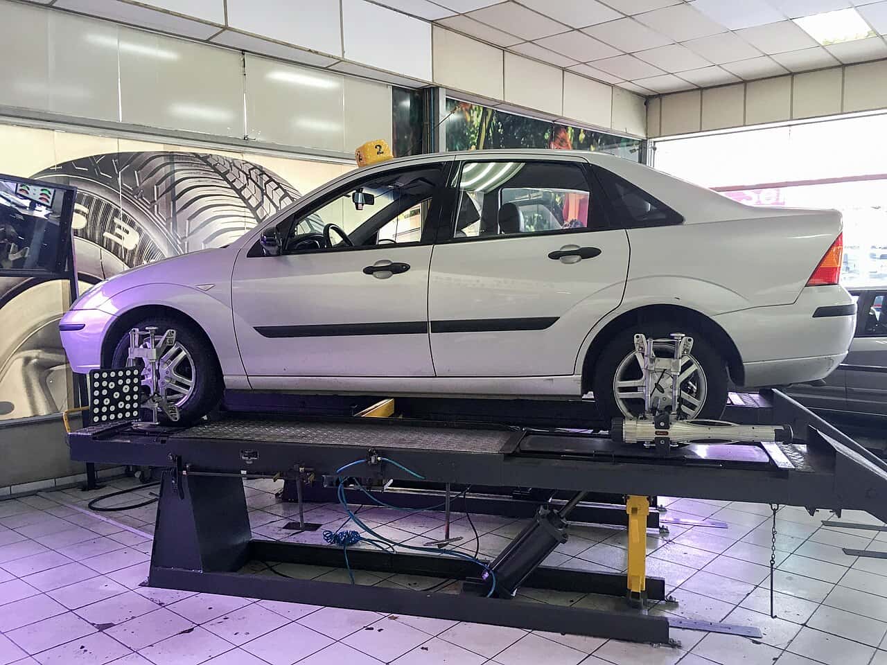 A Ford Focus on an alignment rack with measurement targets attached to its wheels