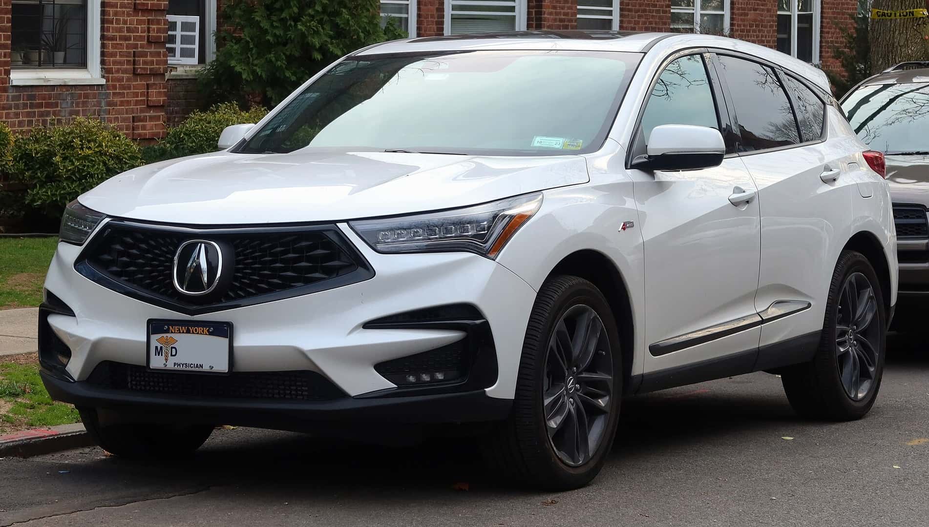 Front three-quarter view of a white 2021 Acura RDX A-Spec parked in New York