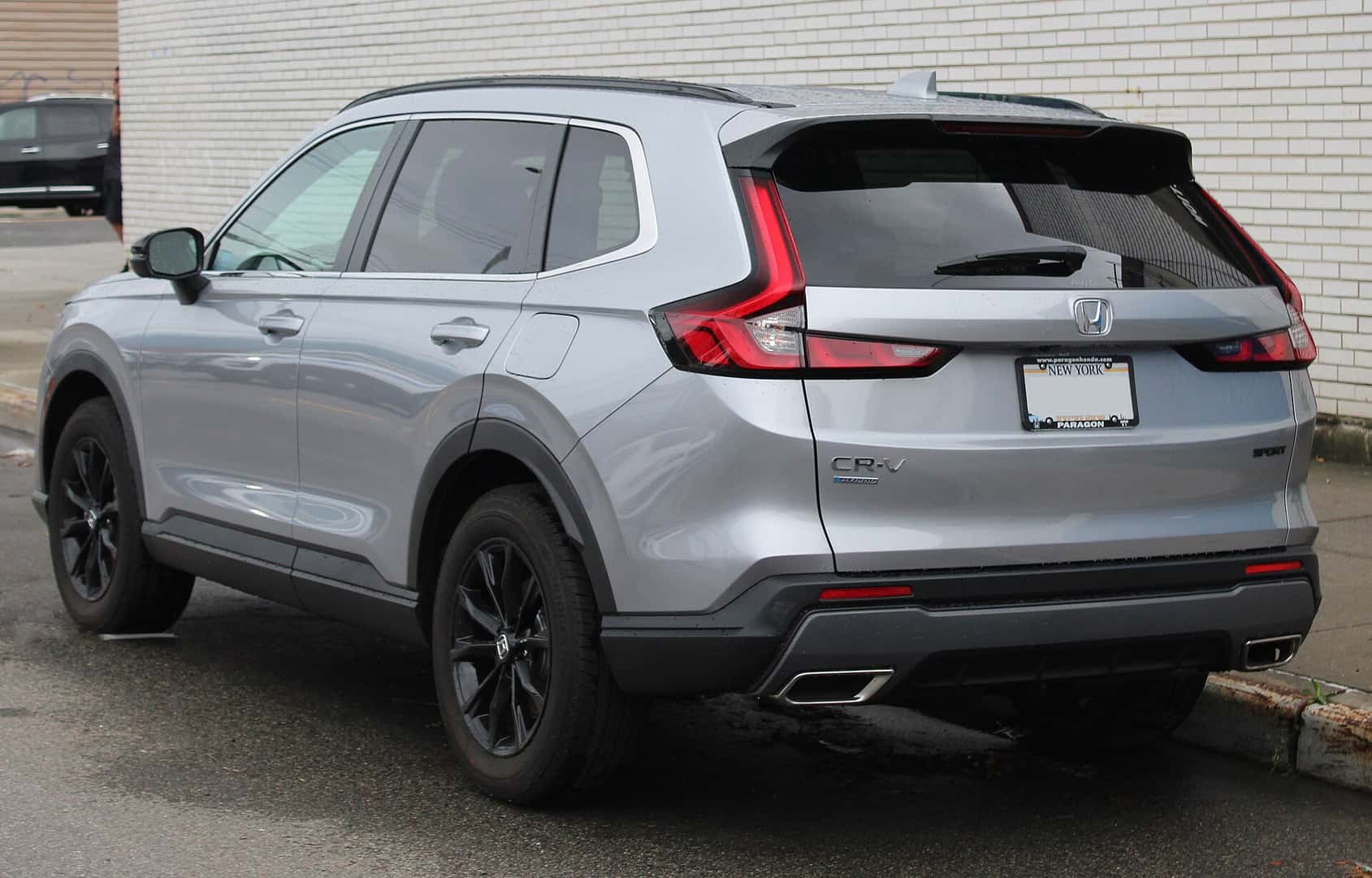 Rear three-quarter view of a silver 2023 Honda CR-V Sport Hybrid parked in New York