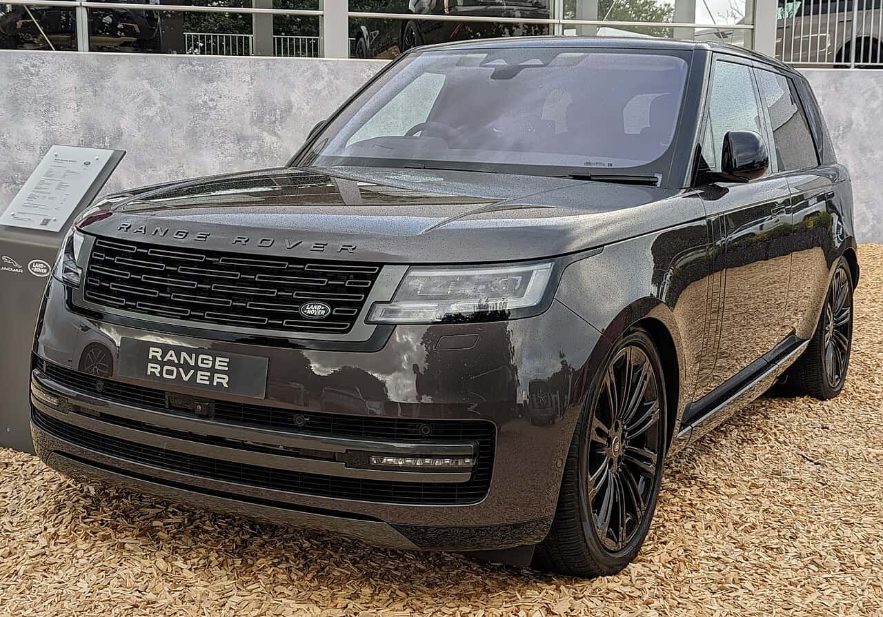 Front three-quarter view of a dark gray Range Rover on display.