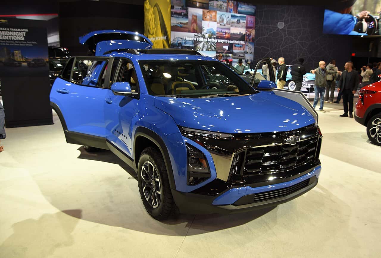 2026 Chevrolet Equinox ACTIV Gasoline SUV Blue 2026 Chevrolet Equinox ACTIV on an indoor auto-show stand, with side doors and the rear liftgate open.