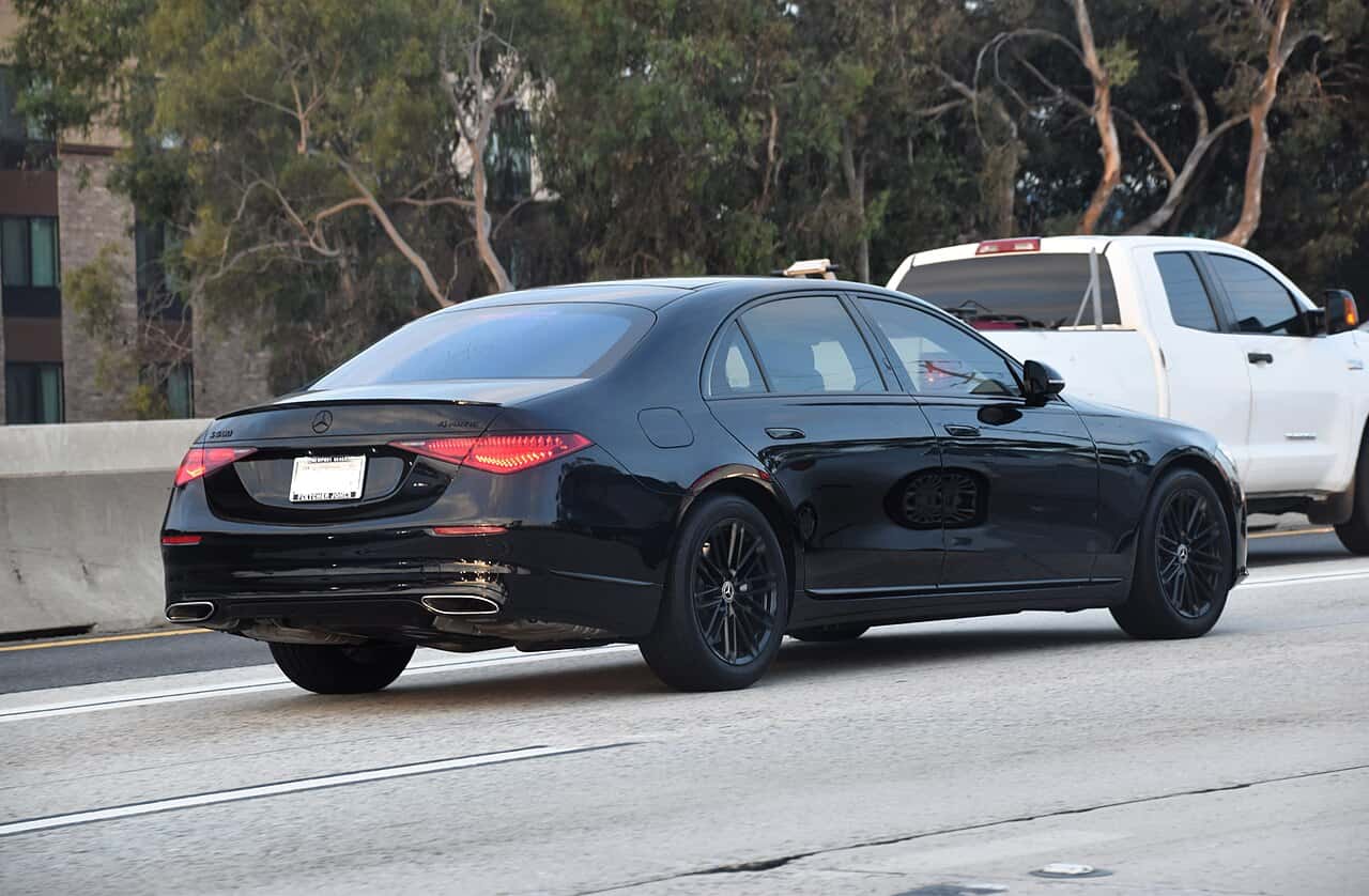 Rear three-quarter view of a black 2023 Mercedes-Benz S 580 4MATIC on a California road.