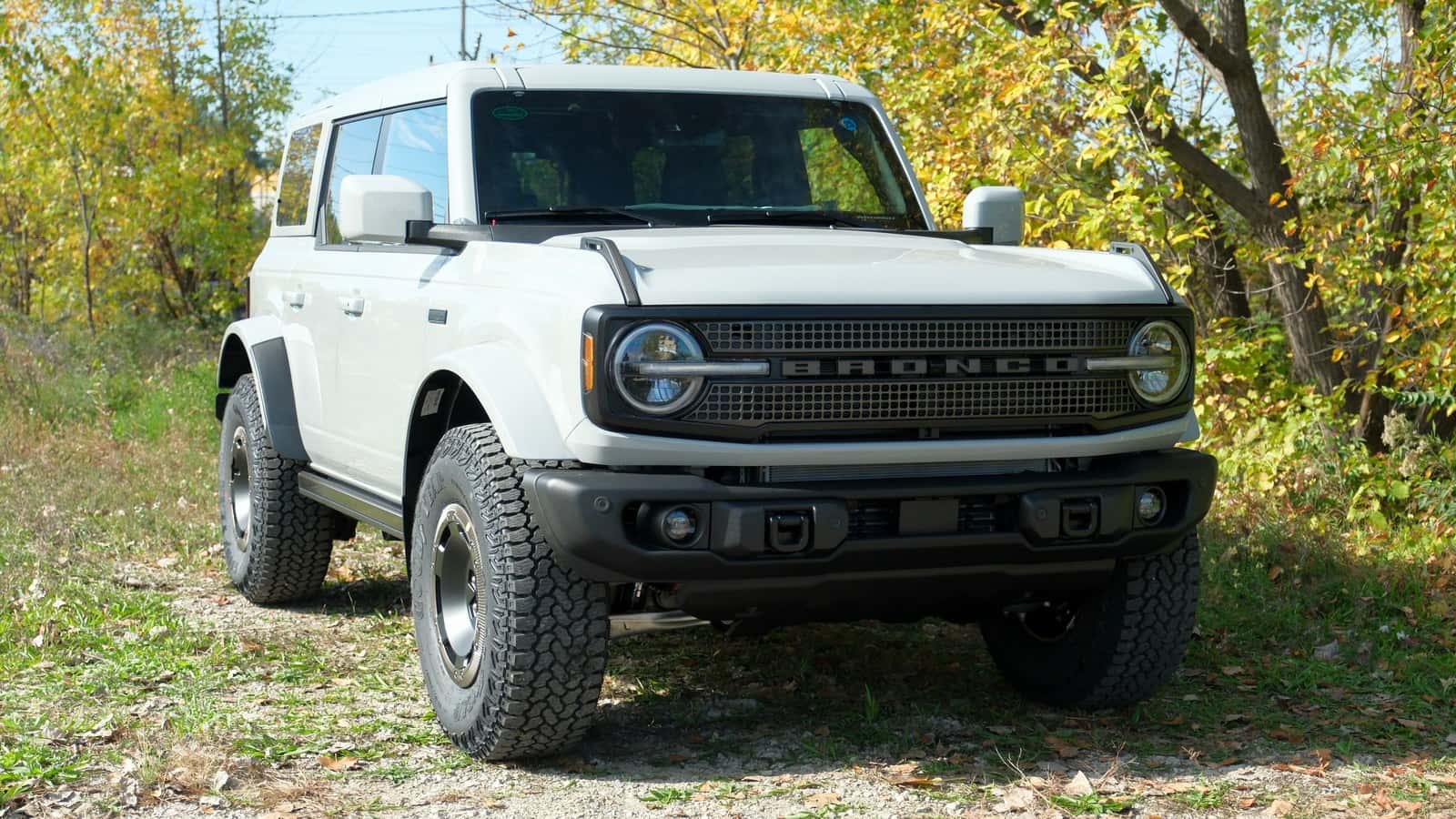 White 2027 Ford Bronco Filson viewed from the front on a wooded trail