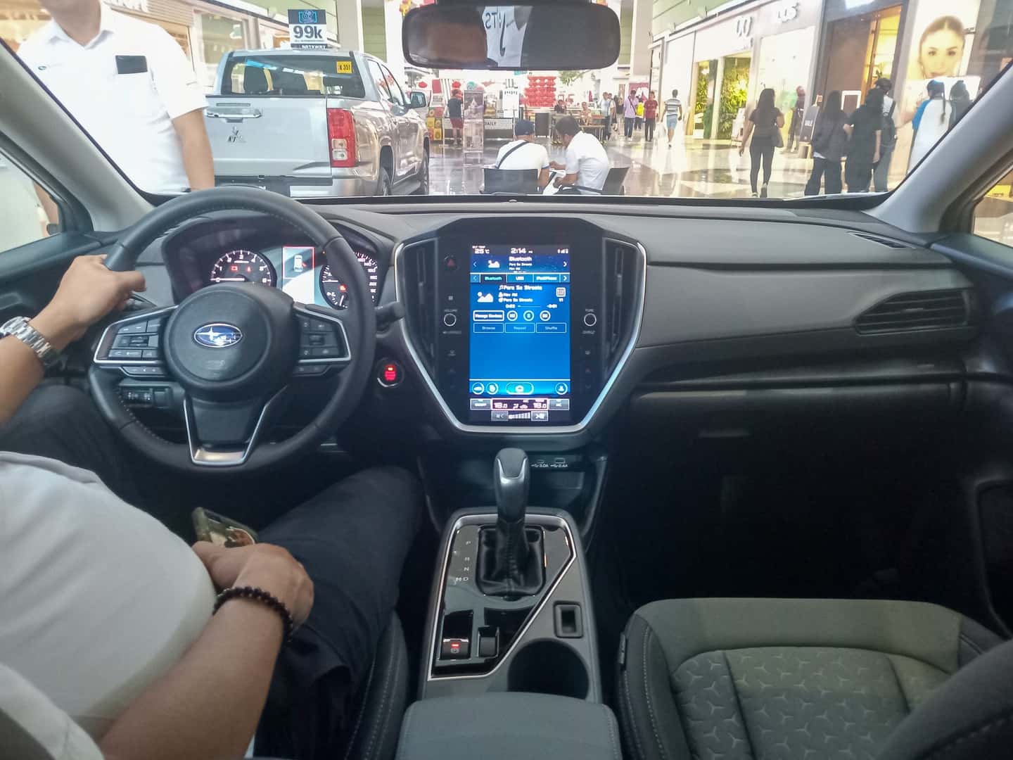 Parked 2024 Subaru Crosstrek interior with steering wheel, left windshield pillar and view through the windshield