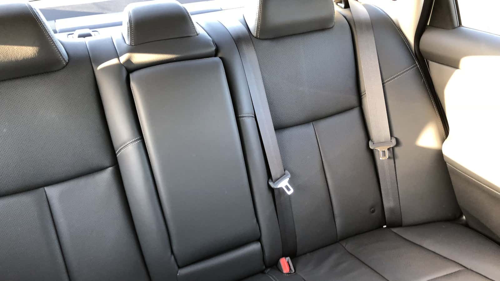 Nissan Altima rear seat with shoulder belts, head restraints and red seat-belt buckles.