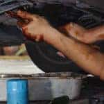 Car mechanic loosening oil filter