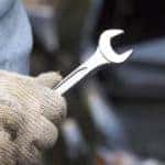 Man with glove holding a wrench