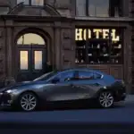 2026 Mazda3 Hatchback parked on city street with modern building background in Hempstead NY