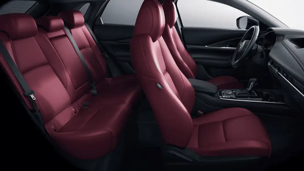 2026 Mazda CX-30 interior near Uniondale NY showing full red leather seating across front and rear rows with black steering wheel and center console