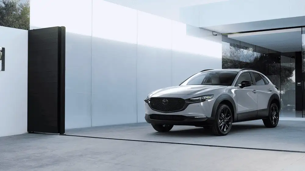 2026 Mazda CX-30 near Uniondale NY in silver parked outside a modern minimalist home with large glass doors