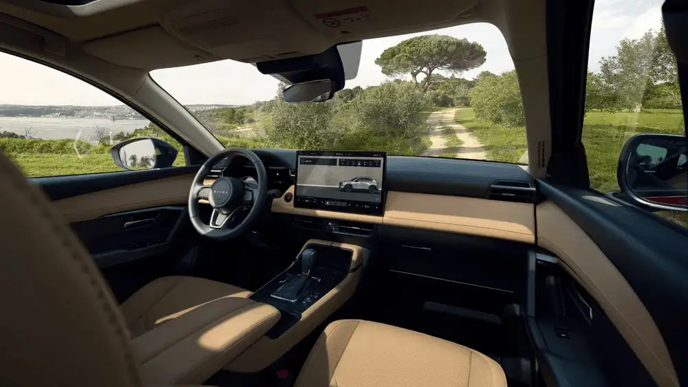 2026 Mazda CX-5 near Uniondale NY dashboard with wide touchscreen infotainment, beige leather seats, and scenic countryside road visible through windshield