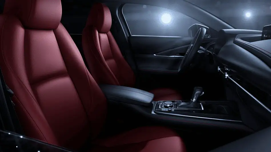 2026 Mazda CX-30 out to Corona NY in Queens interior at night showing red leather front seats, black center console with rotary dial, and ambient cabin lighting