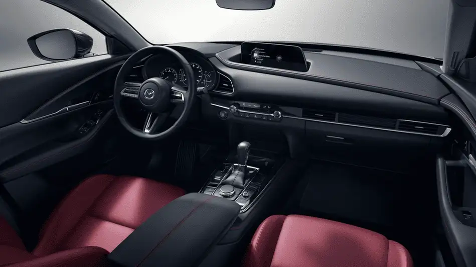 2026 Mazda CX-30 out to Corona NY in Queens cockpit view with red and black leather seats, Mazda infotainment display, and automatic gear selector