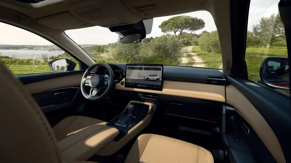 2026 Mazda CX-5 out to Corona NY in Queens dashboard interior with beige leather seats, wide touchscreen infotainment, and scenic countryside road through windshield