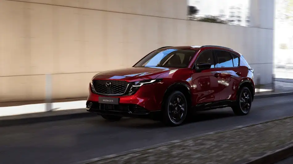 2026 Mazda CX-5 out to Corona NY in Queens in Soul Red Crystal with black wheels driving under an urban overpass in natural daylight