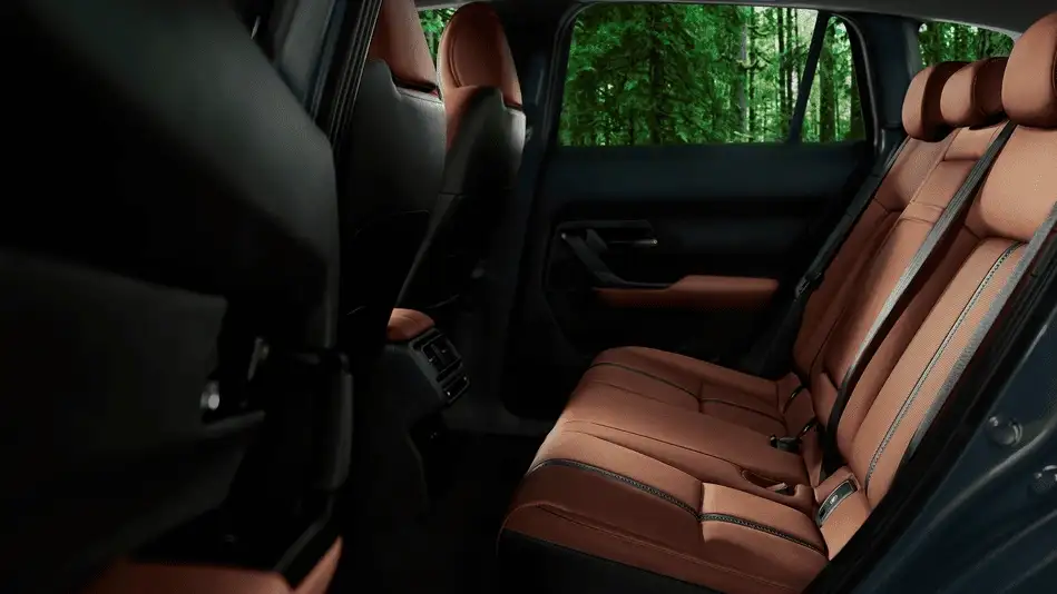 2026 Mazda CX-50 out to Corona NY in Queens rear passenger seats in tan leather with black trim and dense green forest visible through rear windows