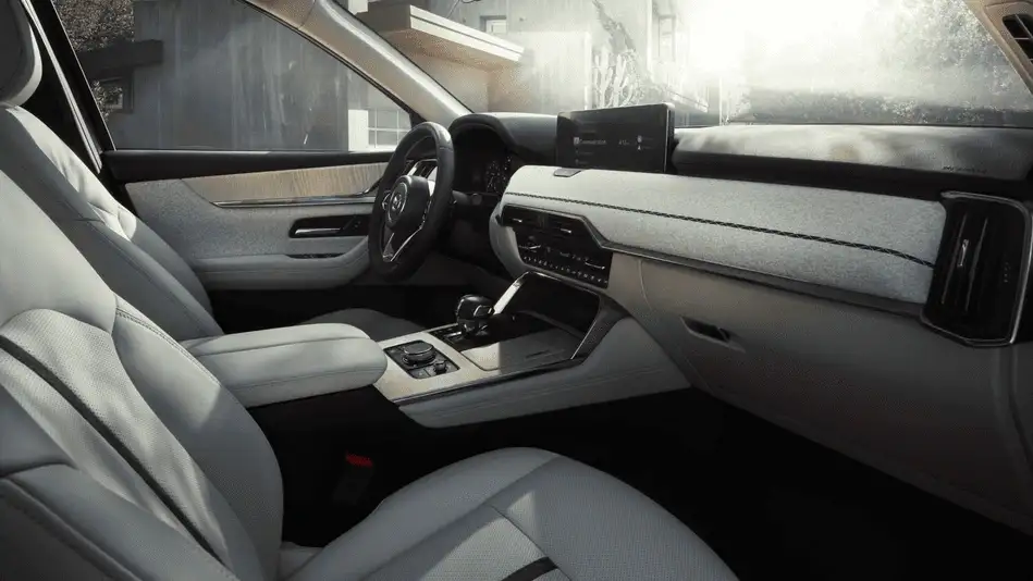 2026 Mazda CX-90 Plug-In Hybrid out to Corona NY in Queens interior with light gray leather seats, wood trim center console, and infotainment display in sunlit cabin