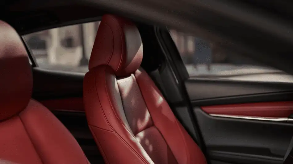2026 Mazda3 Hatchback out to Corona NY in Queens close-up of red leather rear passenger seat headrest with sunlit urban street visible through side window