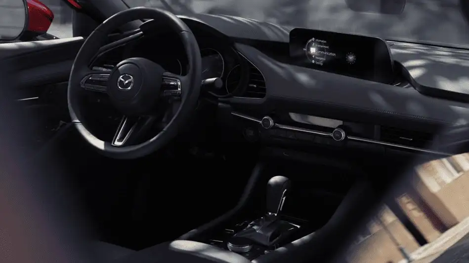 2026 Mazda3 Sedan out to Corona NY in Queens driver-side interior with all-black dashboard, Mazda infotainment screen, and automatic gear selector