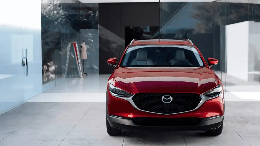 2026 Mazda CX-30 near Uniondale NY, red SUV facing forward parked beside glass storefront windows