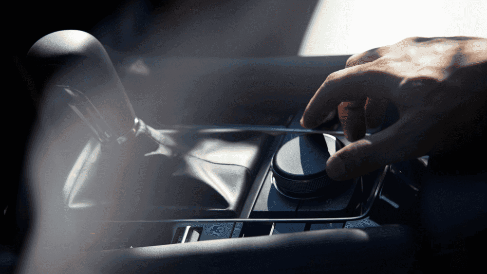 2026 Mazda3 Hatchback near Hempstead NY, hand adjusting the rotary control knob on the black center console