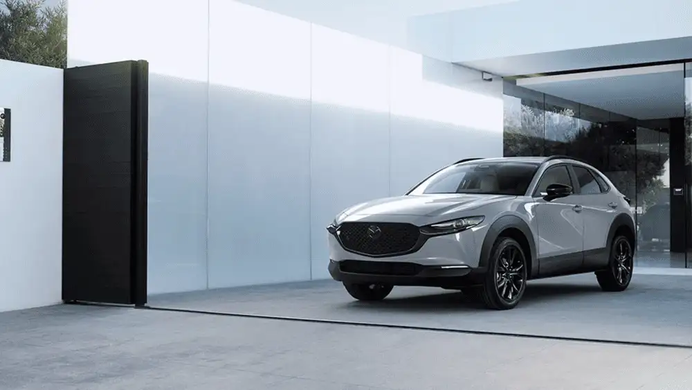 2026 Mazda CX-30 near Hempstead NY, silver SUV parked outside a modern home with a black entry door and glass facade