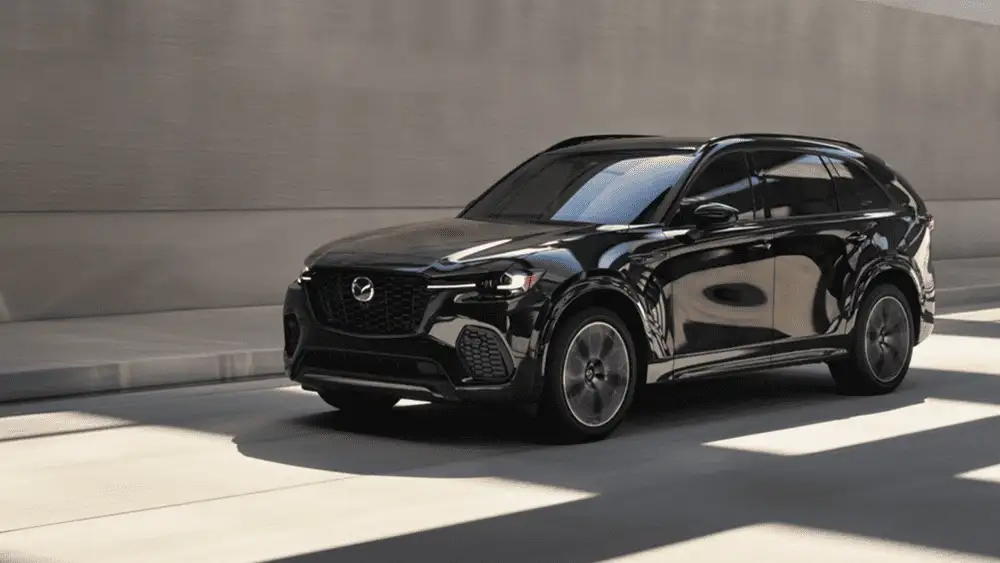2026 Mazda CX-70 near Hempstead NY, jet black SUV driving through a sunlit modern parking structure