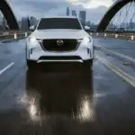 2026 Mazda CX-90 Plug-In Hybrid in white crossing a bridge near Uniondale, NY, vs. Volvo XC90 Recharge.