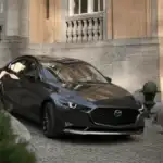 2026 Mazda3 Sedan in gray parked at a stone estate driveway near Uniondale, NY