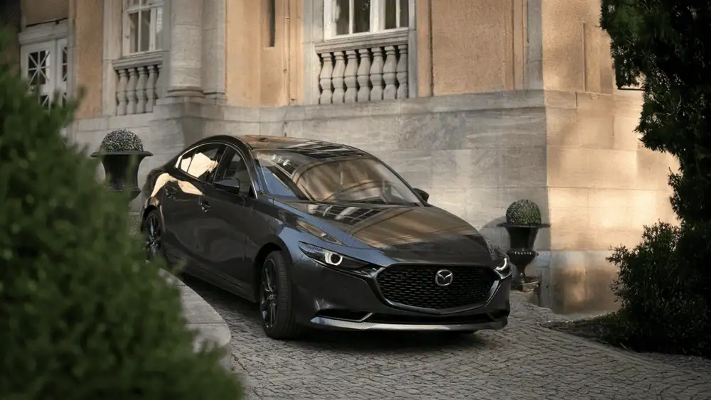 2026 Mazda3 Sedan in gray parked at a stone estate driveway near Uniondale, NY