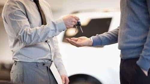 Man giving keys to another man
