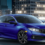 Blue Honda Civic Sport parked in front of tall buildings