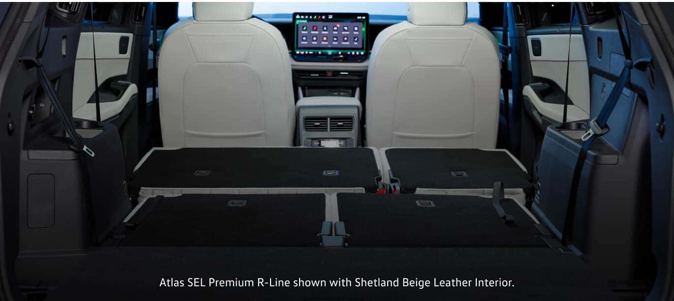 Shetland Beige Leather interior of a 2027 Volkswagen Atlas Premium R-Line cargo area with flat-folded second and third-row rear seats.