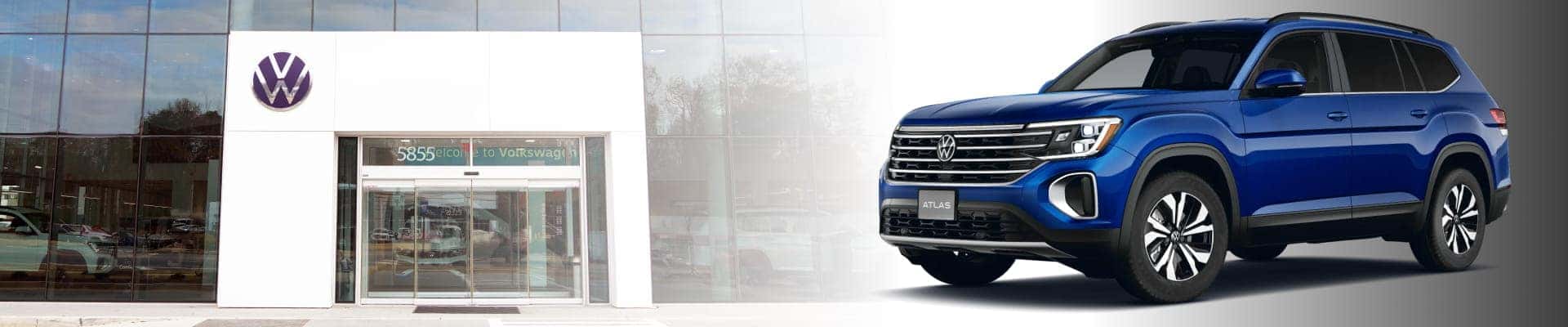 Blue Volkswagen Atlas displayed beside the exterior of a Volkswagen dealership.