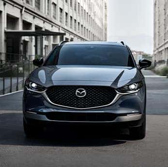 Lancaster Mazda is a Mazda Dealership near  East Petersburg, PA | Blue CX-30 driving downtown alone