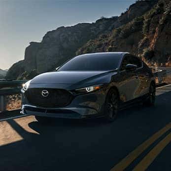 Lancaster Mazda is a Mazda Dealership near  East Petersburg, PA | Blue Mazda3 driving in mountains next to valley